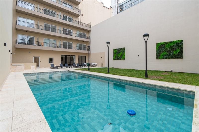 Piscina y espacio verde en el patio del edificio