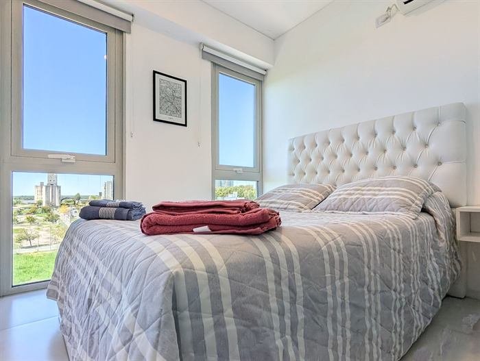Dormitorio con ventanales y vista abierta en el departamento de Natalia en Rosario
